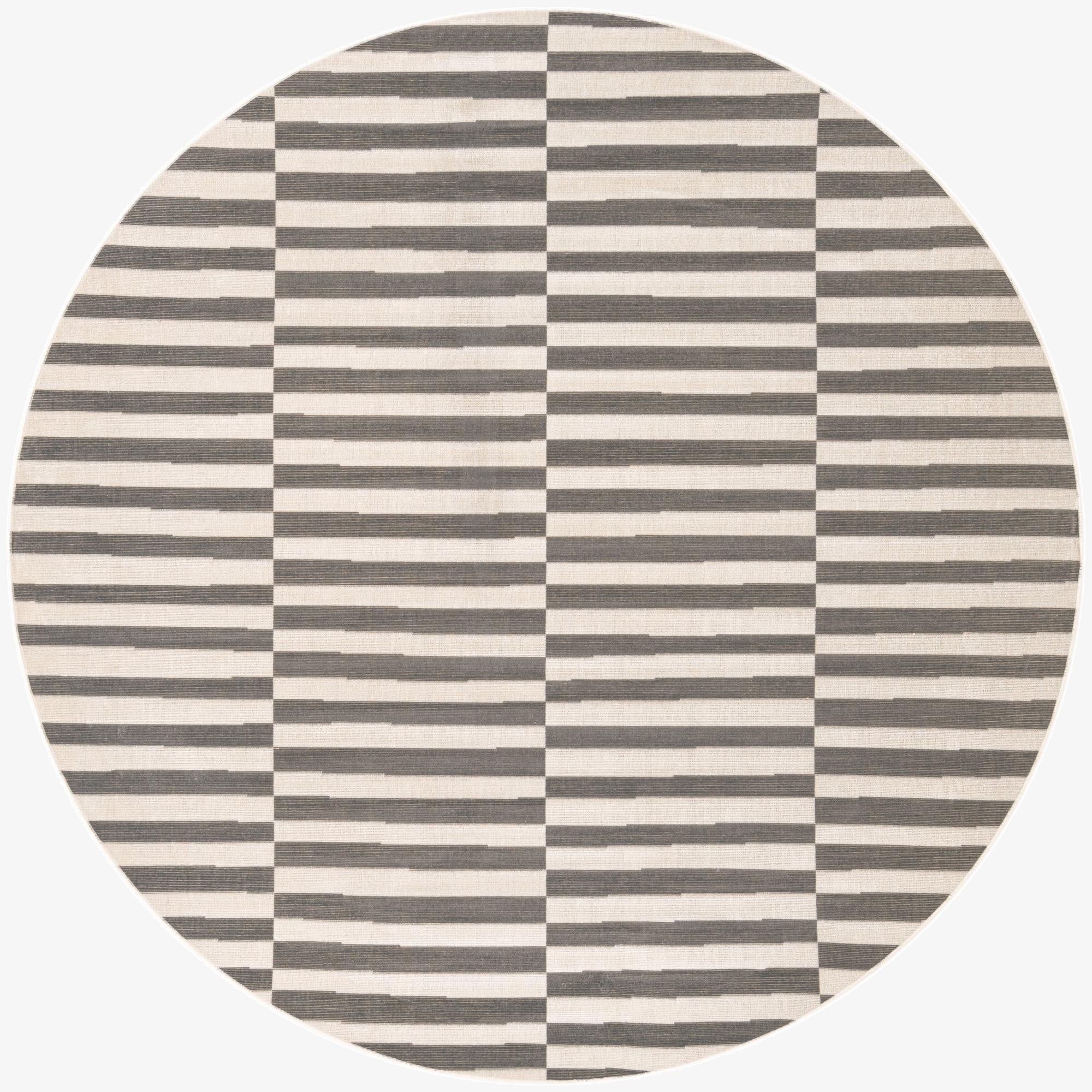A round gray and off-white striped rug with a modern, alternating block pattern, suitable for a contemporary living space.