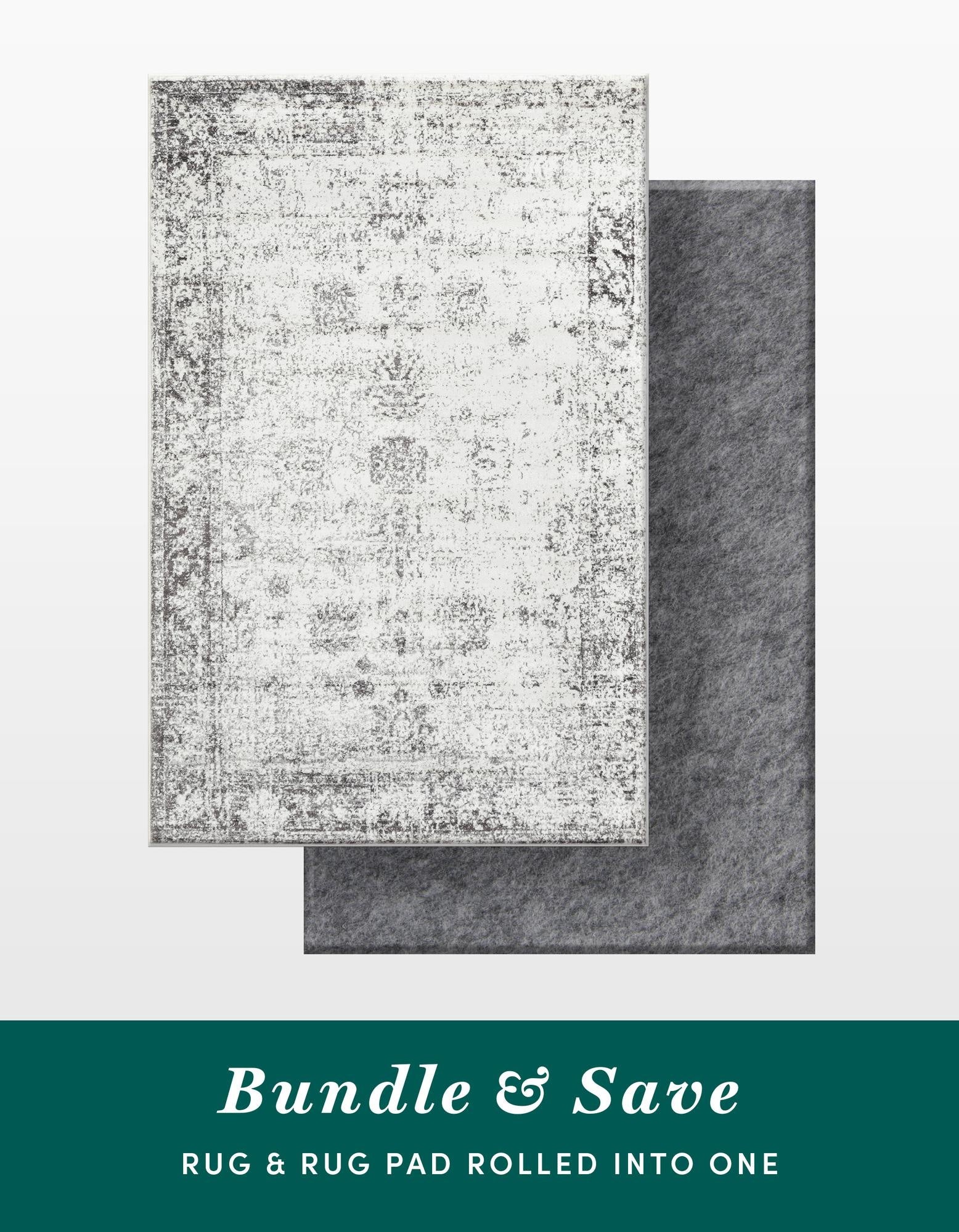 A 5x8 rectangular gray and silver vintage-style rug with a distressed traditional pattern, shown with a dark gray rug pad underneath.