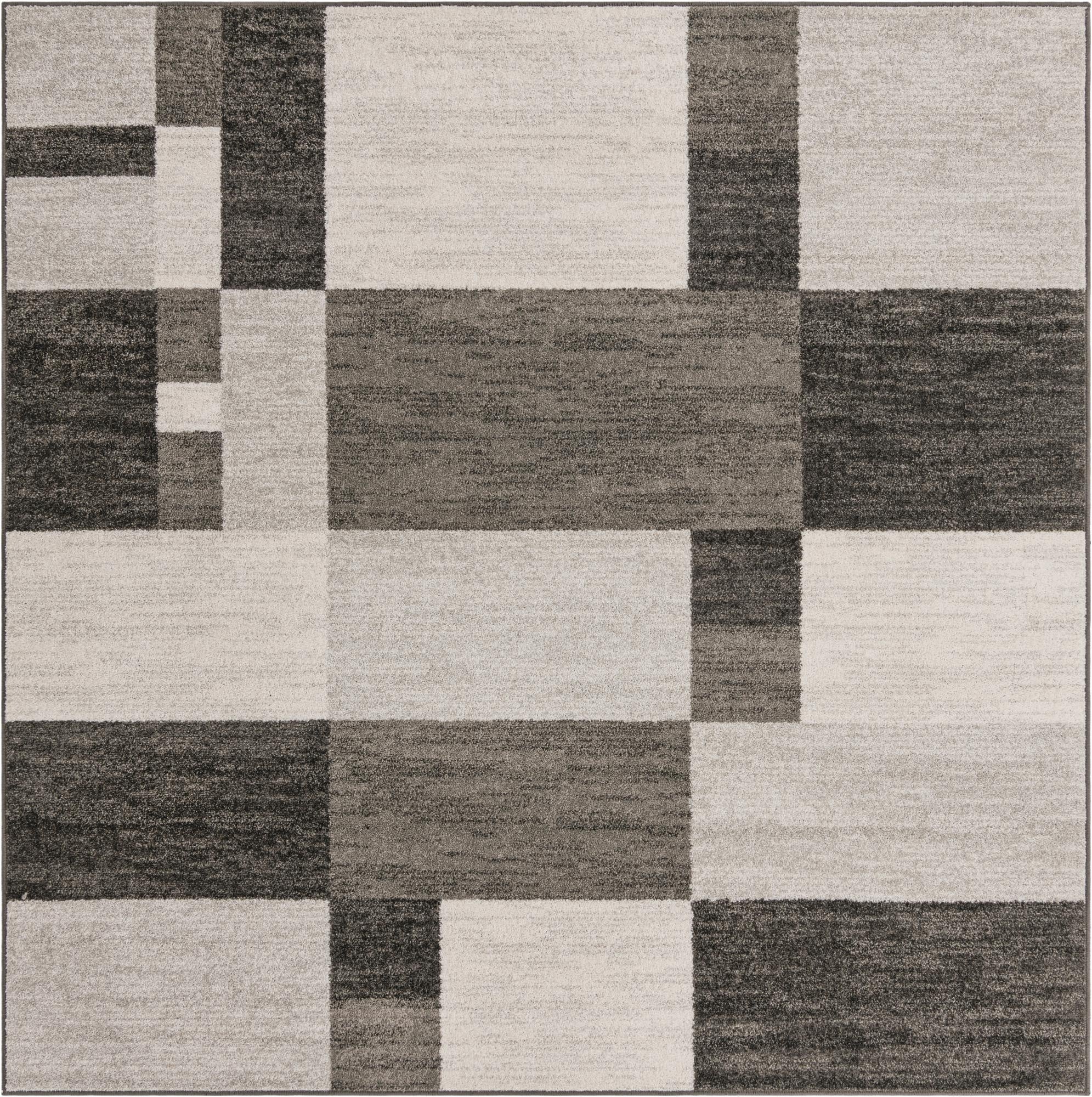A square modern rug featuring a geometric pattern of light gray, medium gray, and dark gray blocks.