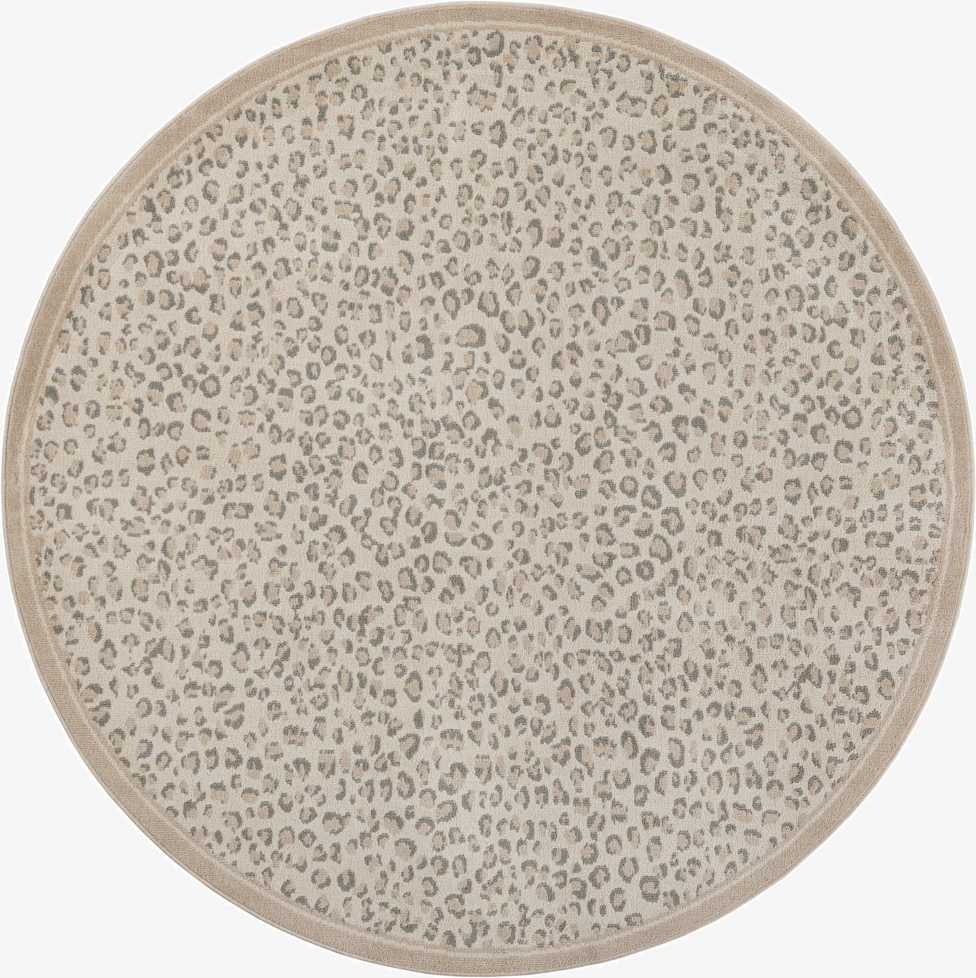 A 7' 10 round ivory and cream rug with a subtle modern leopard print pattern and a thin beige border.