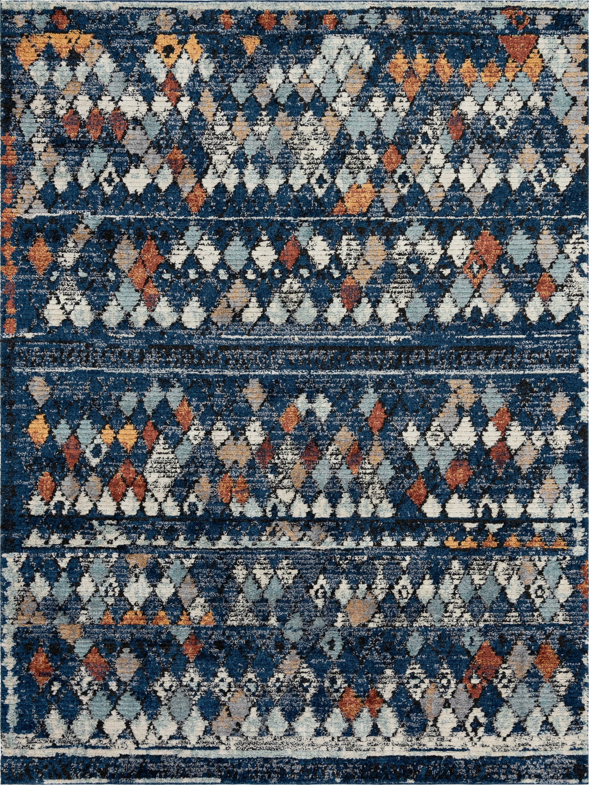A rectangular 9x12 navy blue shag rug with a distressed tribal trellis pattern in white, light blue, and rust orange.