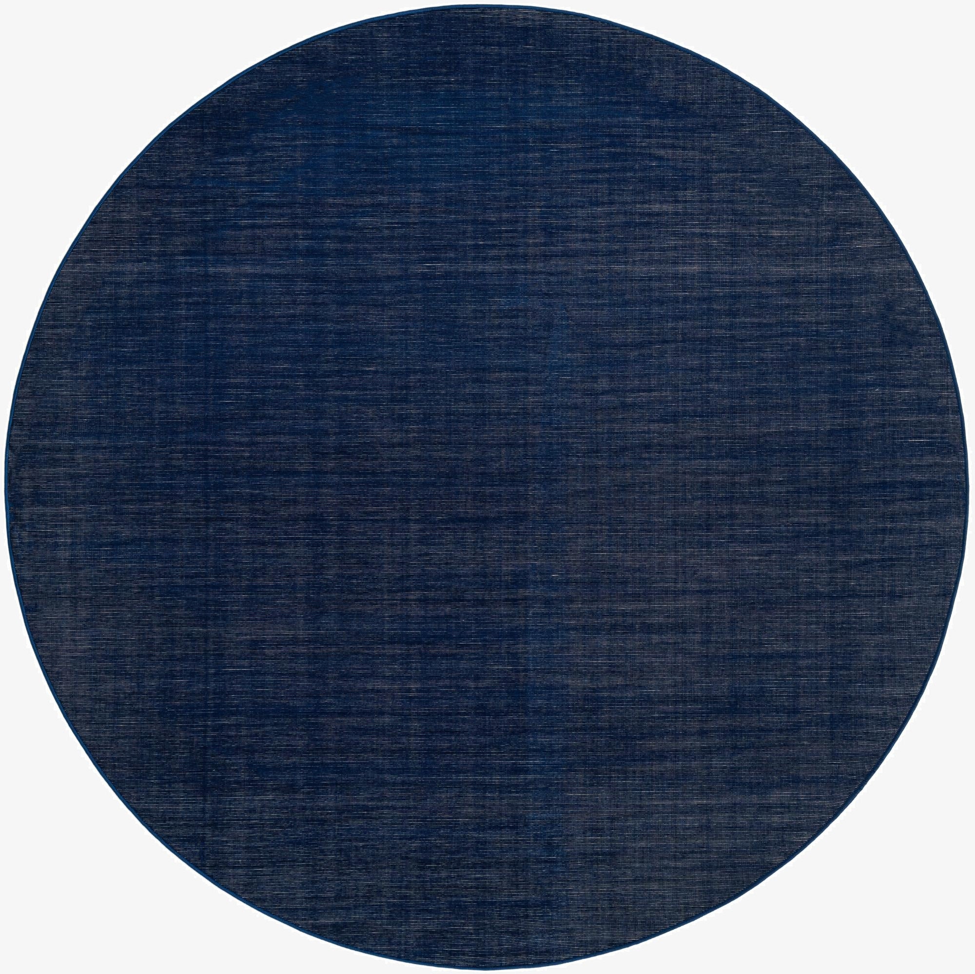 A round, 8' navy blue SoHo rug with a subtle textured flatweave pattern, ideal for an indoor living space.